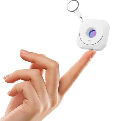 Small white device with a keychain attachment held by a hand on a white background