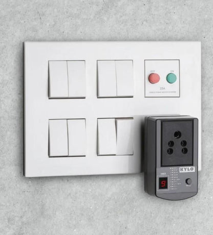 Electrical panel with multiple sockets and switches on a concrete wall.